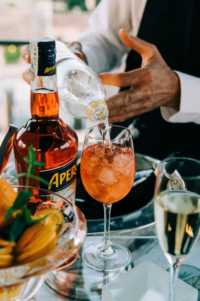 The making of a Spritz - Aperol bottle and a barman