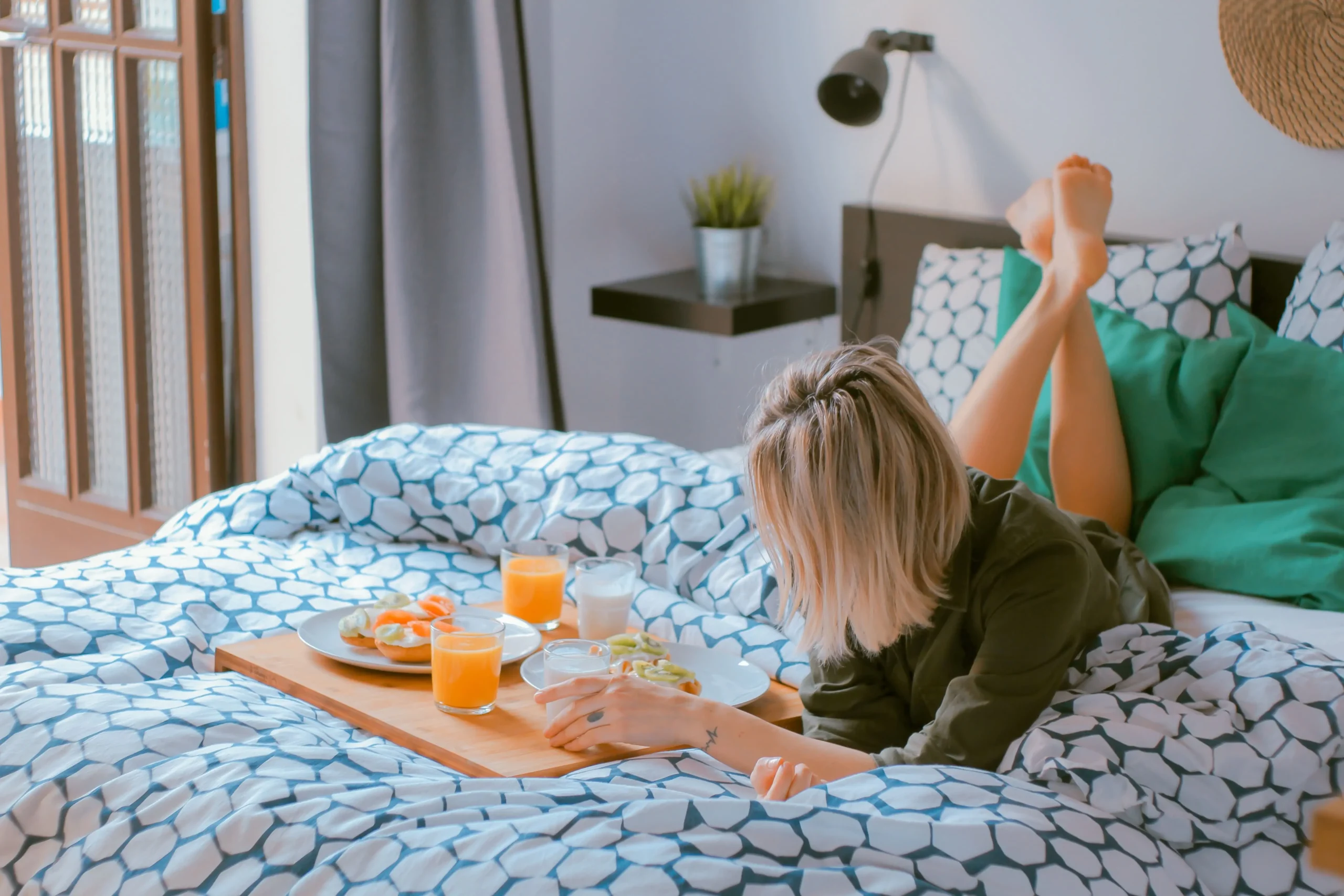 A woman having breakfast in bed during a momcation