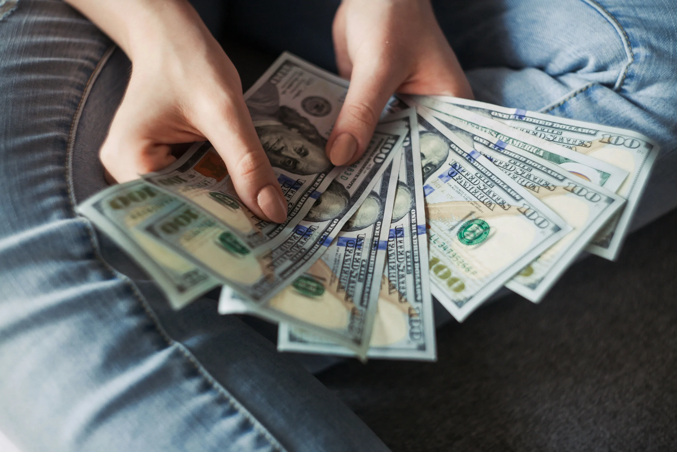 A girl holding some dollars in banknotes.